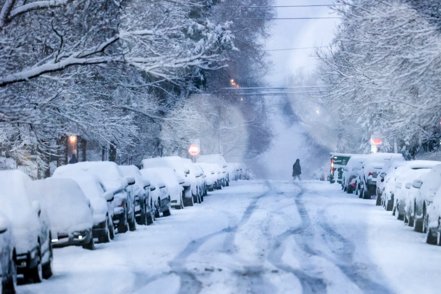 A person crosses a snowy street