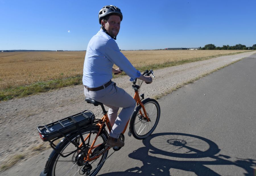 French Junior Minister for Transports Clement Beaune rides an electric bicycle in order to promote soft mobility, between Blandainville and Illiers-Combray, center France, on August 11, 2022.