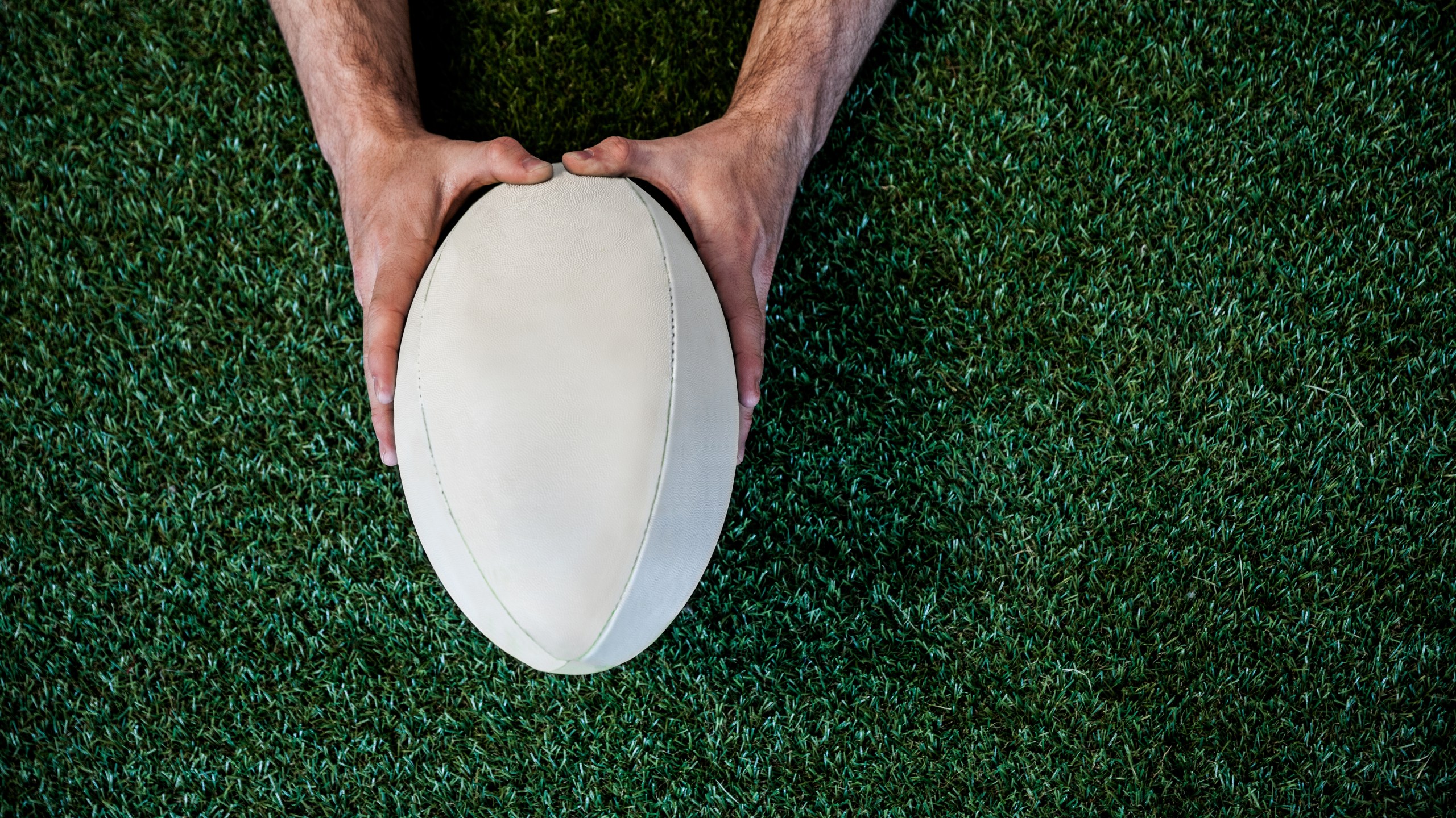 Man holding rugby ball over the grass