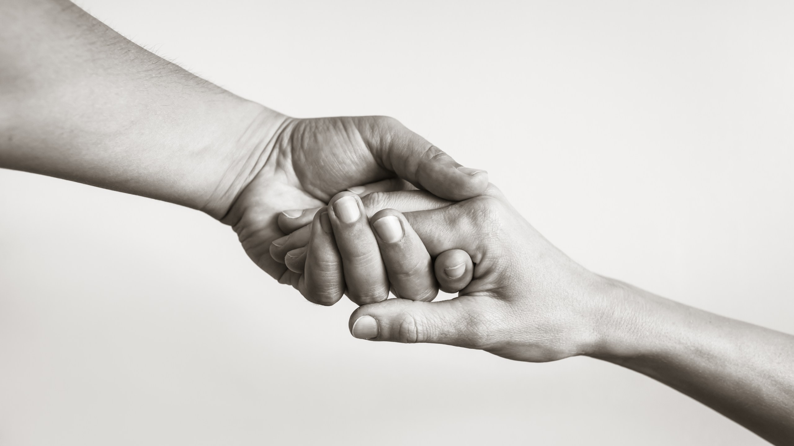 Black and white image of two hands clasping