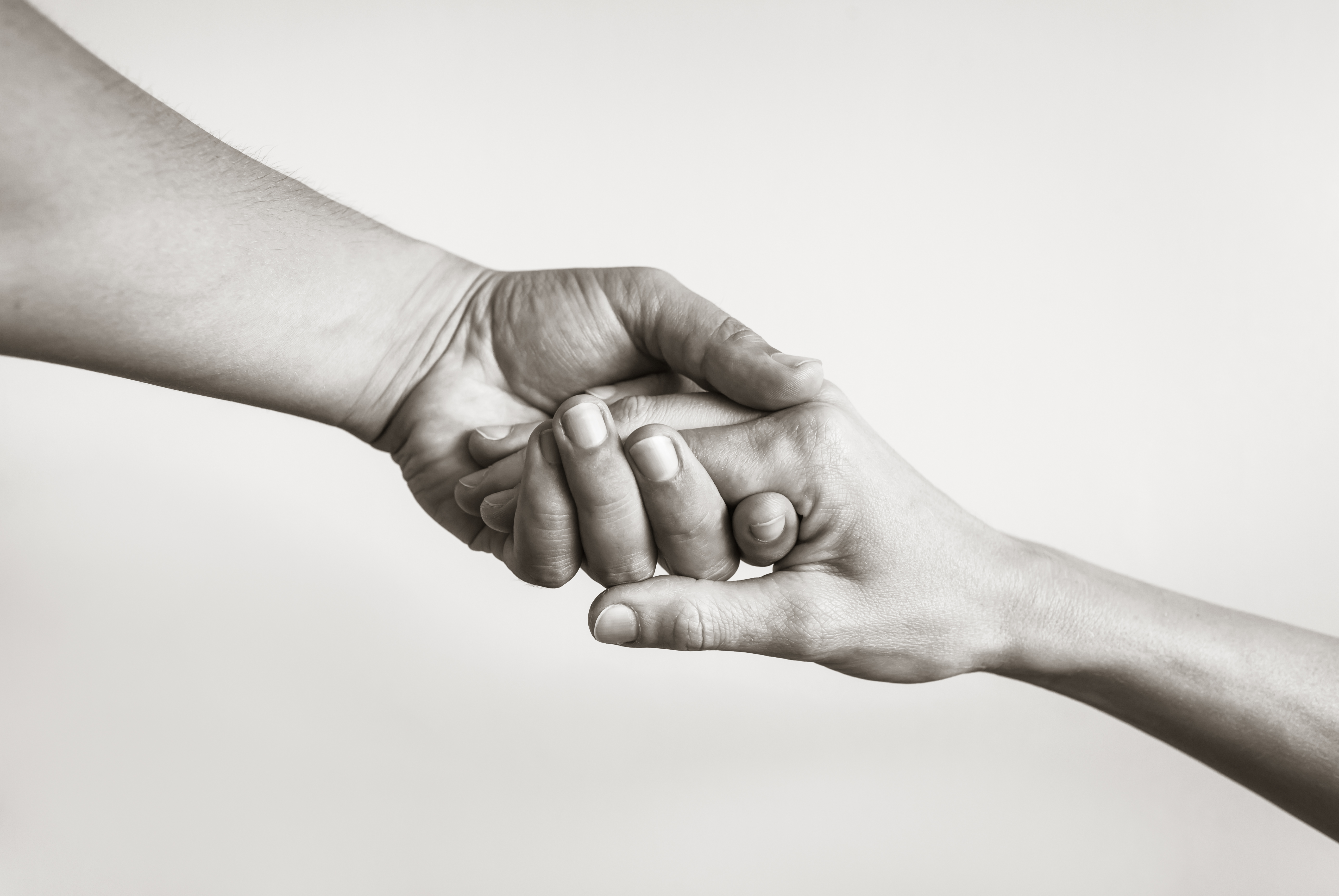 Black and white image of two hands clasping