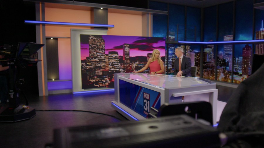 FOX31 Morning News anchors Ashley Ryan and Kirk Yuhnke at the anchor desk on FOX31's new set.