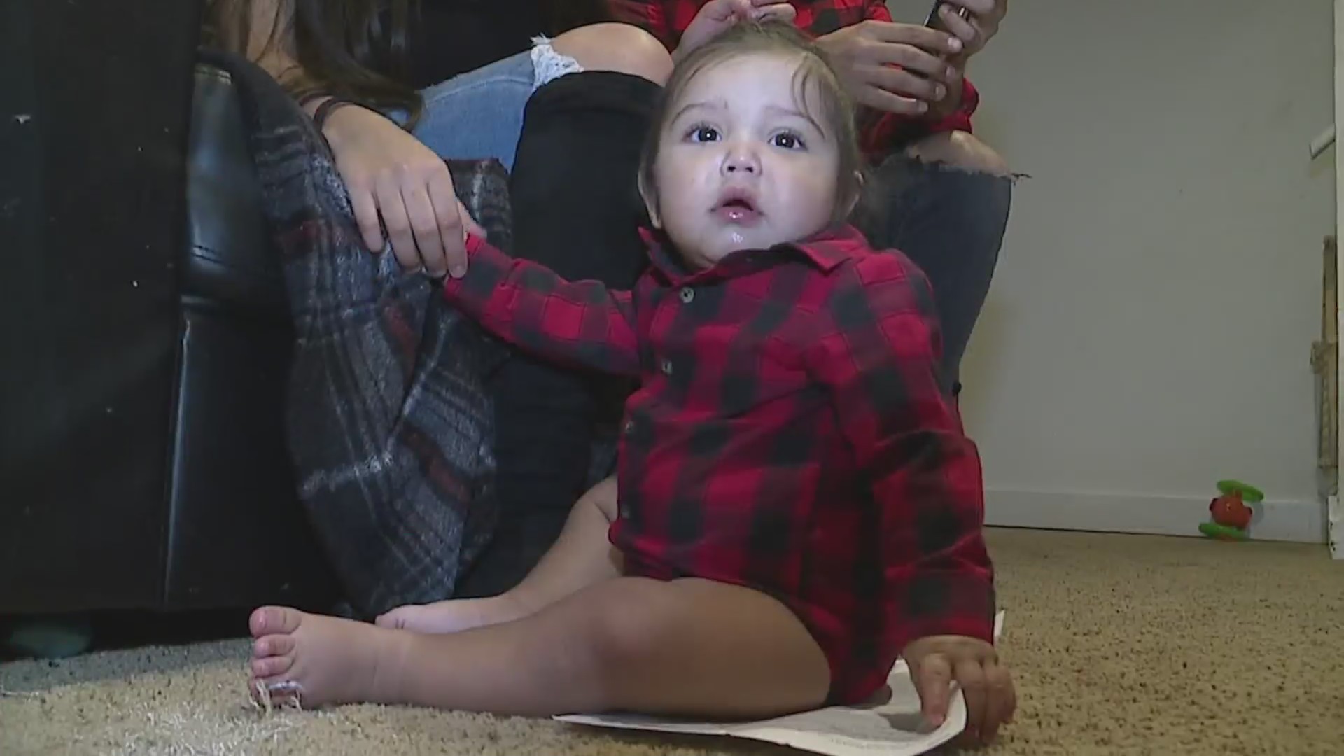 Baby sits on the floor and looks at the camera