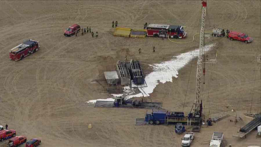 Aerial view of burned oil tank surrounded by foam