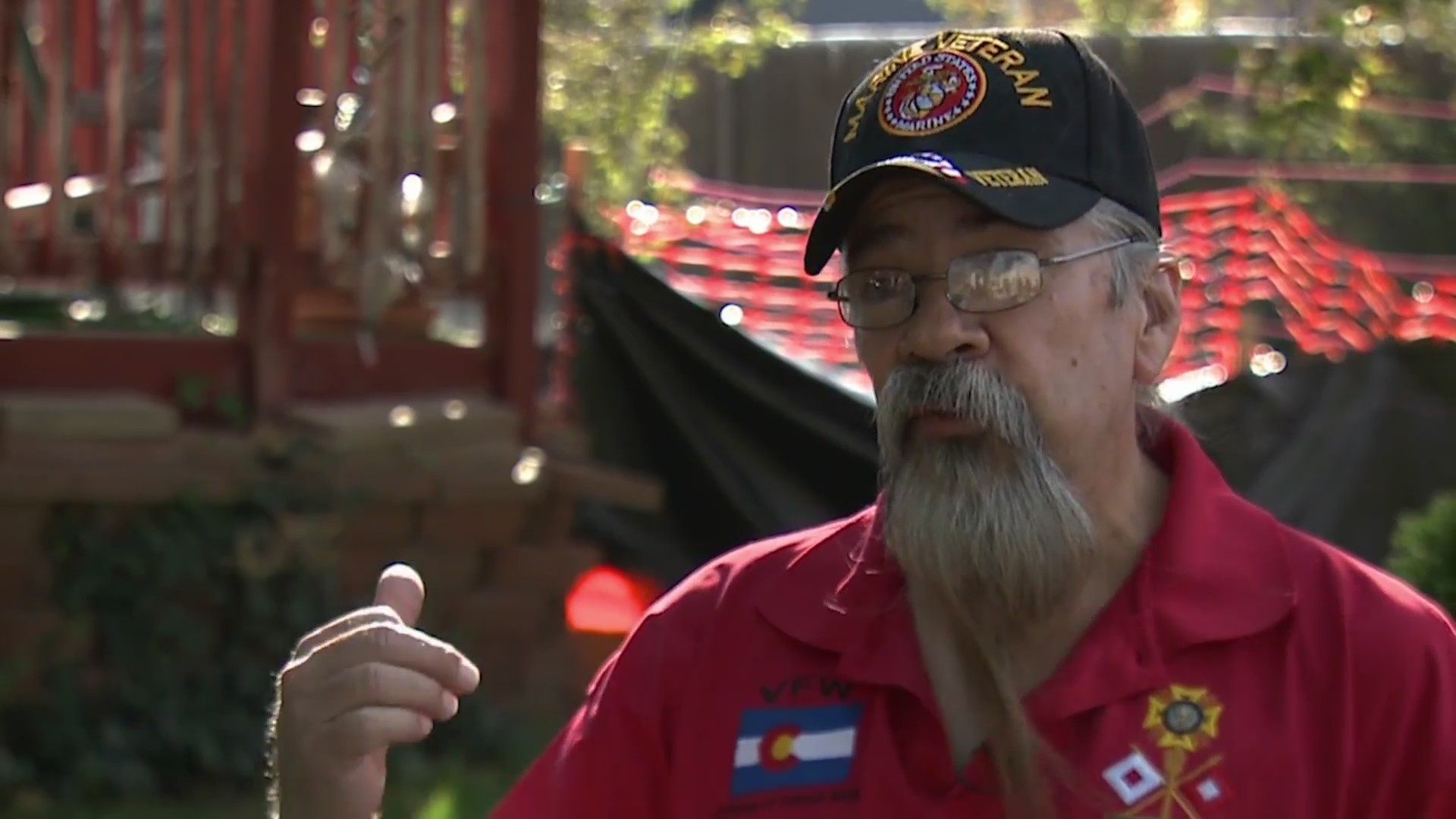 An older white man with a beard, glasses and a veteran ballcap