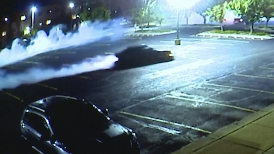 Cars do burnouts in parking lot