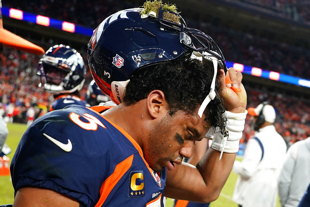 Denver Broncos quarterback Russell Wilson removes his helmet after a concussion against the Kansas City Chiefs during the second half of an NFL football game, Sunday, Dec. 11, 2022, in Denver.