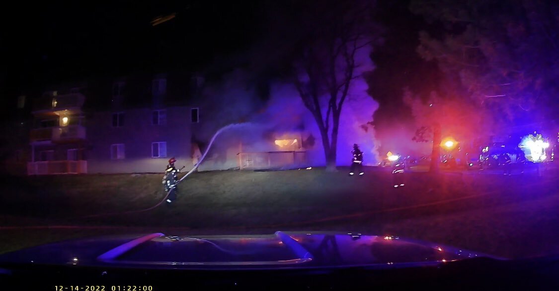 Firefighters hose a burning apartment building at night