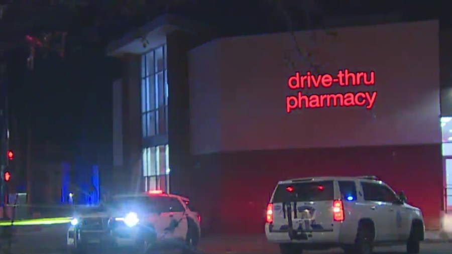 Two police SUVs in a pharmacy parking with crime scene tape at night