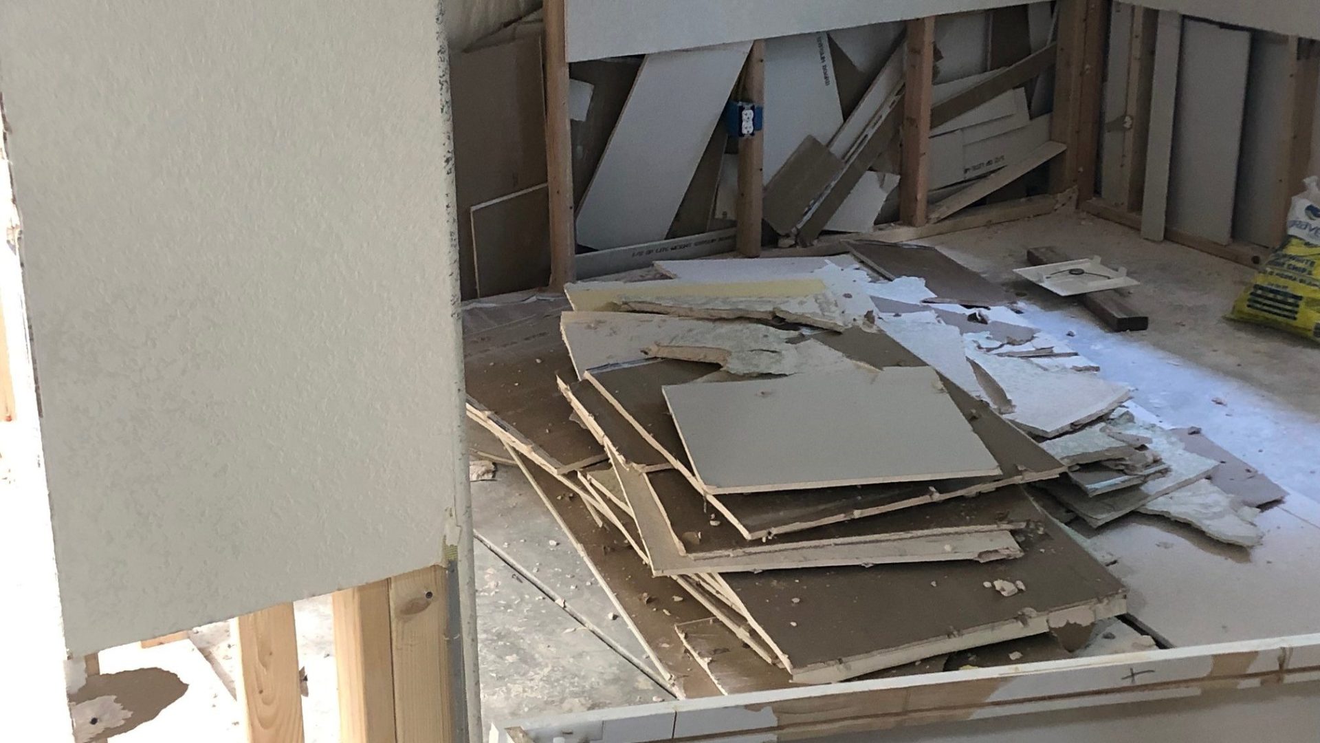 A stack of broken drywall on the floor