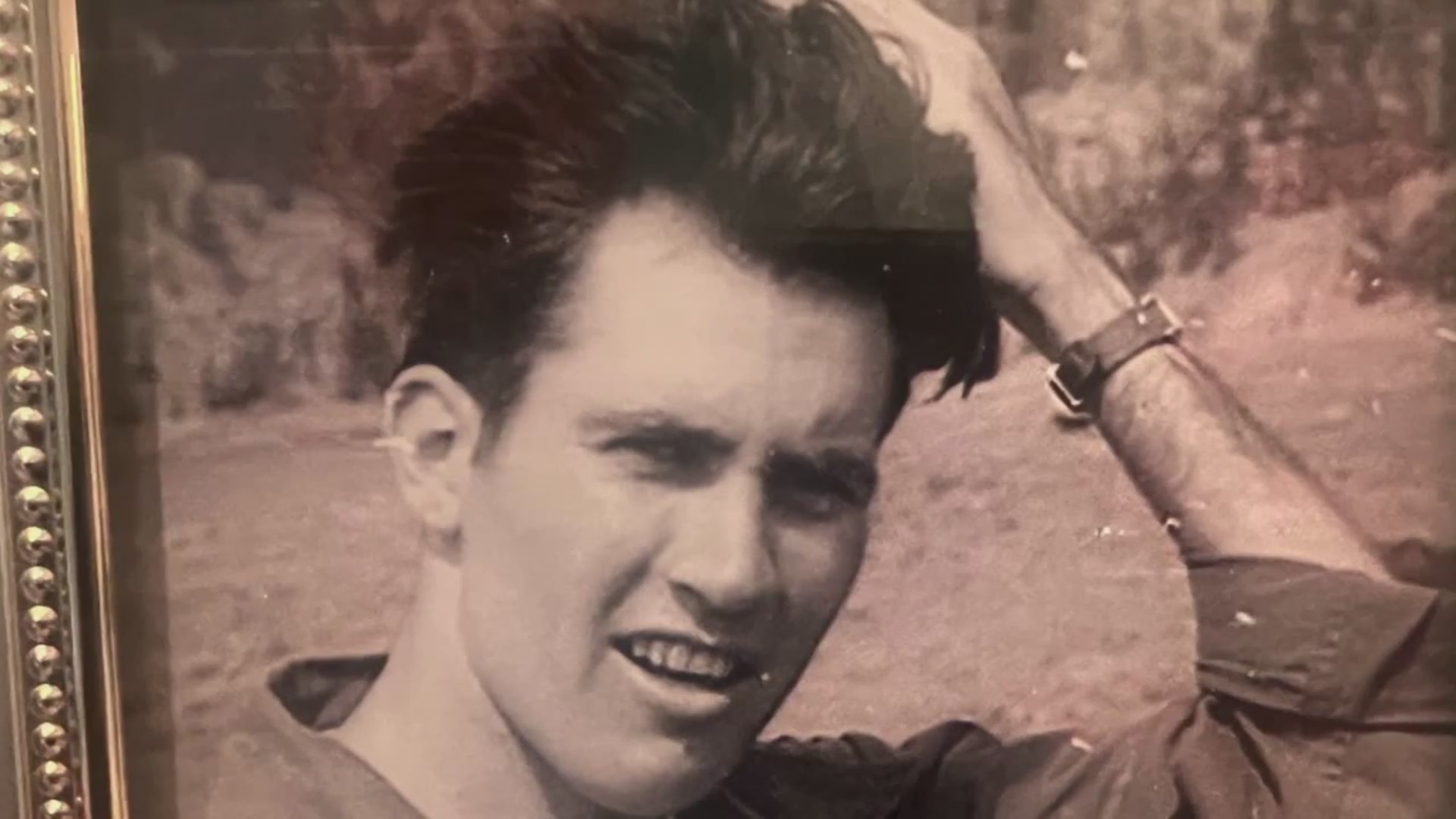 A black and white photo of a young man looking into the camera