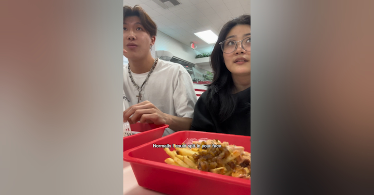 Screen grab of a vertical video showing two young people and their plates of food