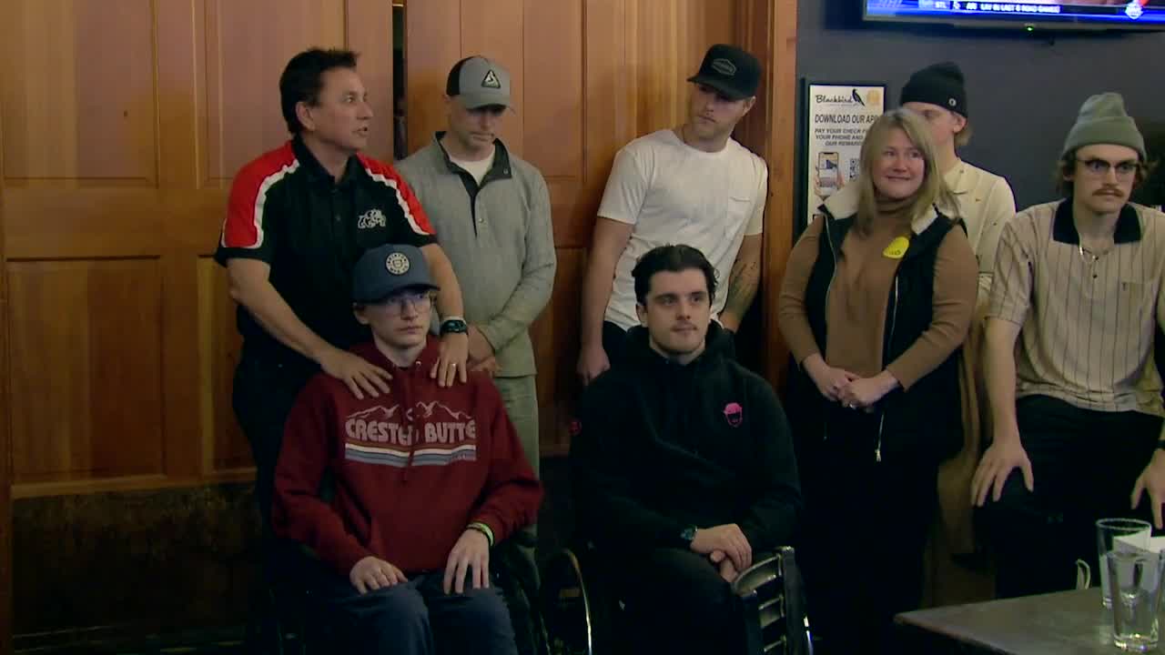 Young man in a chair surrounded by people