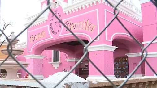 Casa Bonita's pink exterior pictured through a construction fence