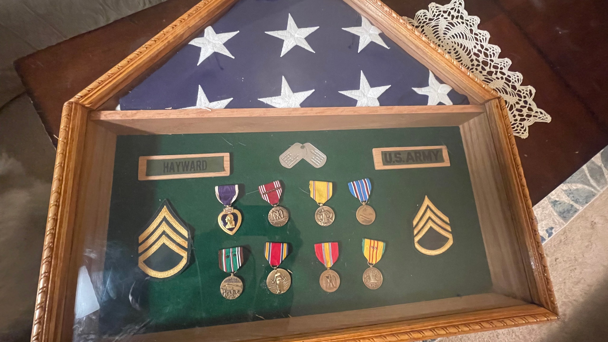 A frame with a folded US flag and numerous military medals from WWII, Vietnam