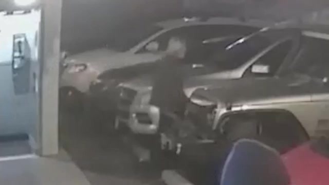 Surveillance image of a man leaving a building into a parking lot