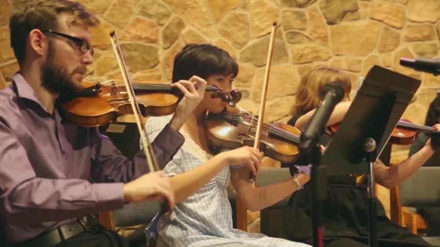 Young violinists play in an orchestra