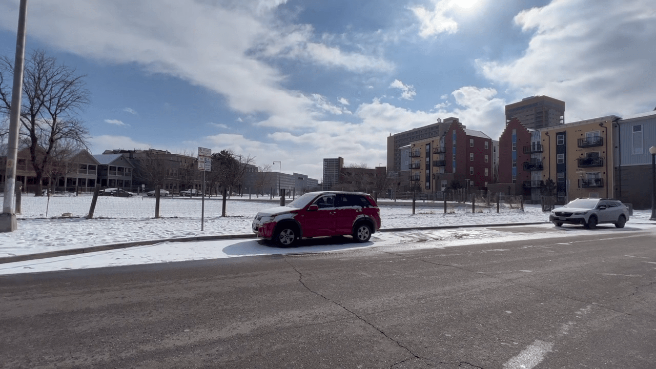 Cars parked on a street near a Denver dog park