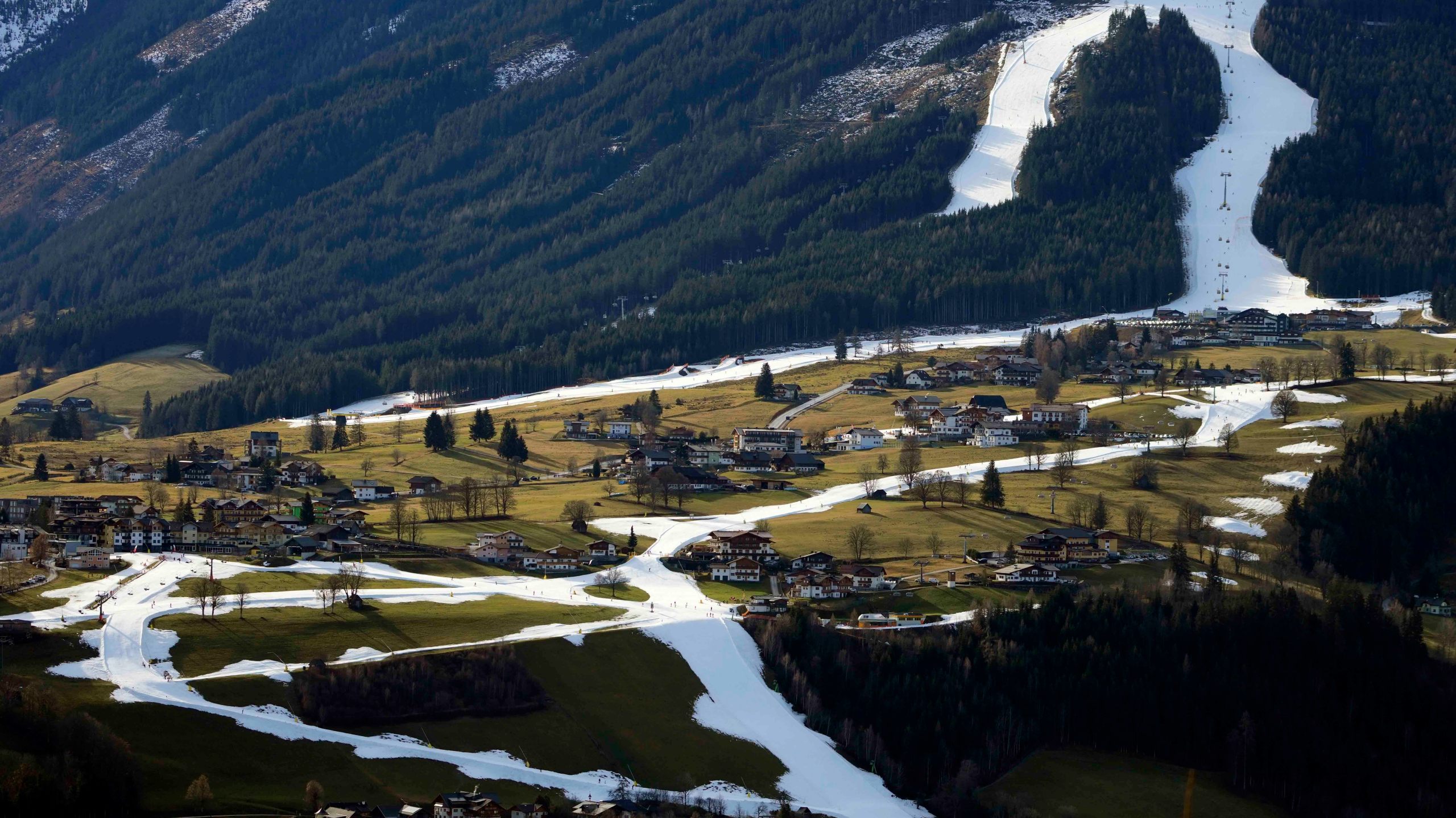 People ski on a strip of snow near Schladming, Austria