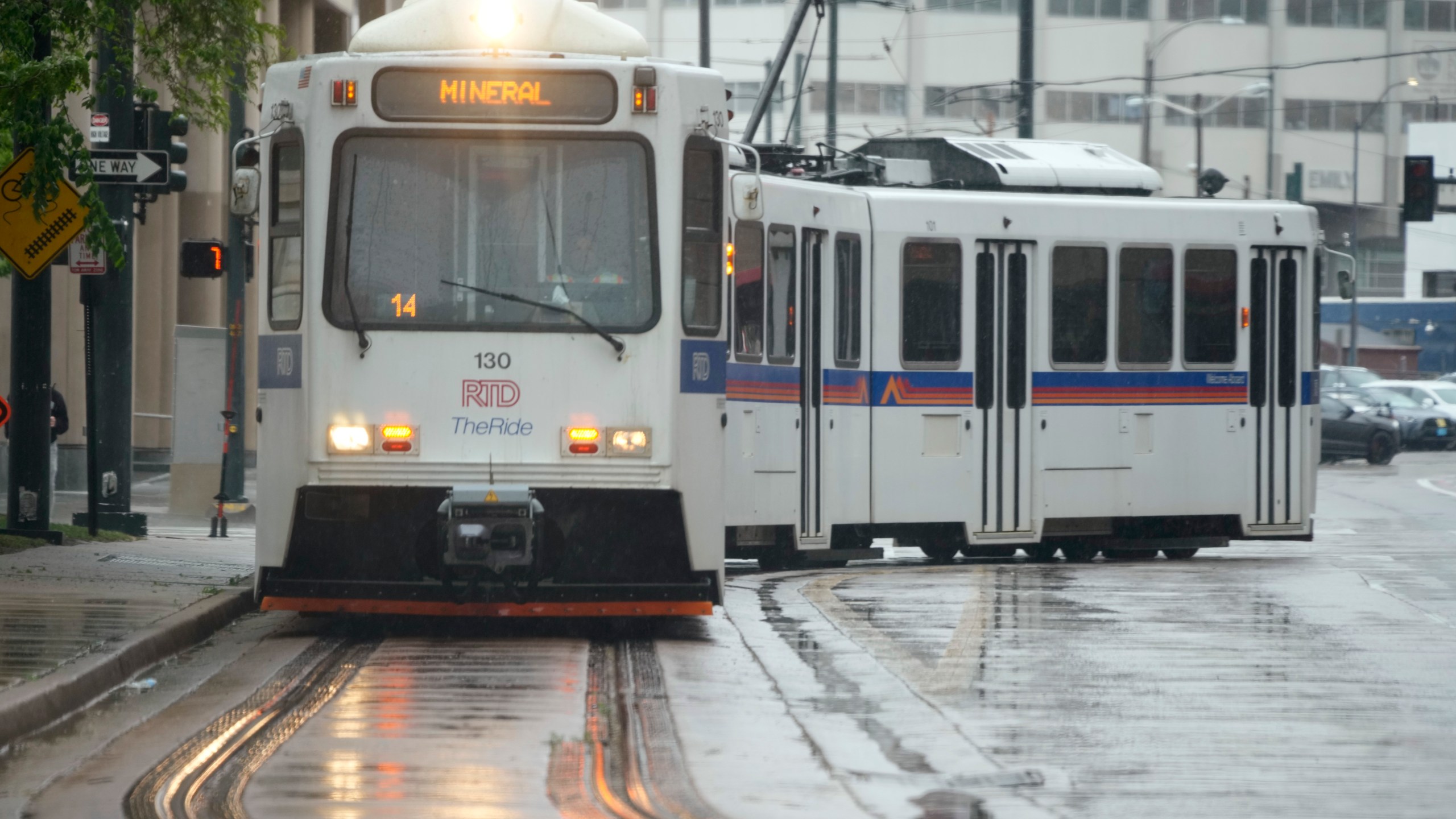 A Regional Transportation District light rail train moves along 19th Avenue