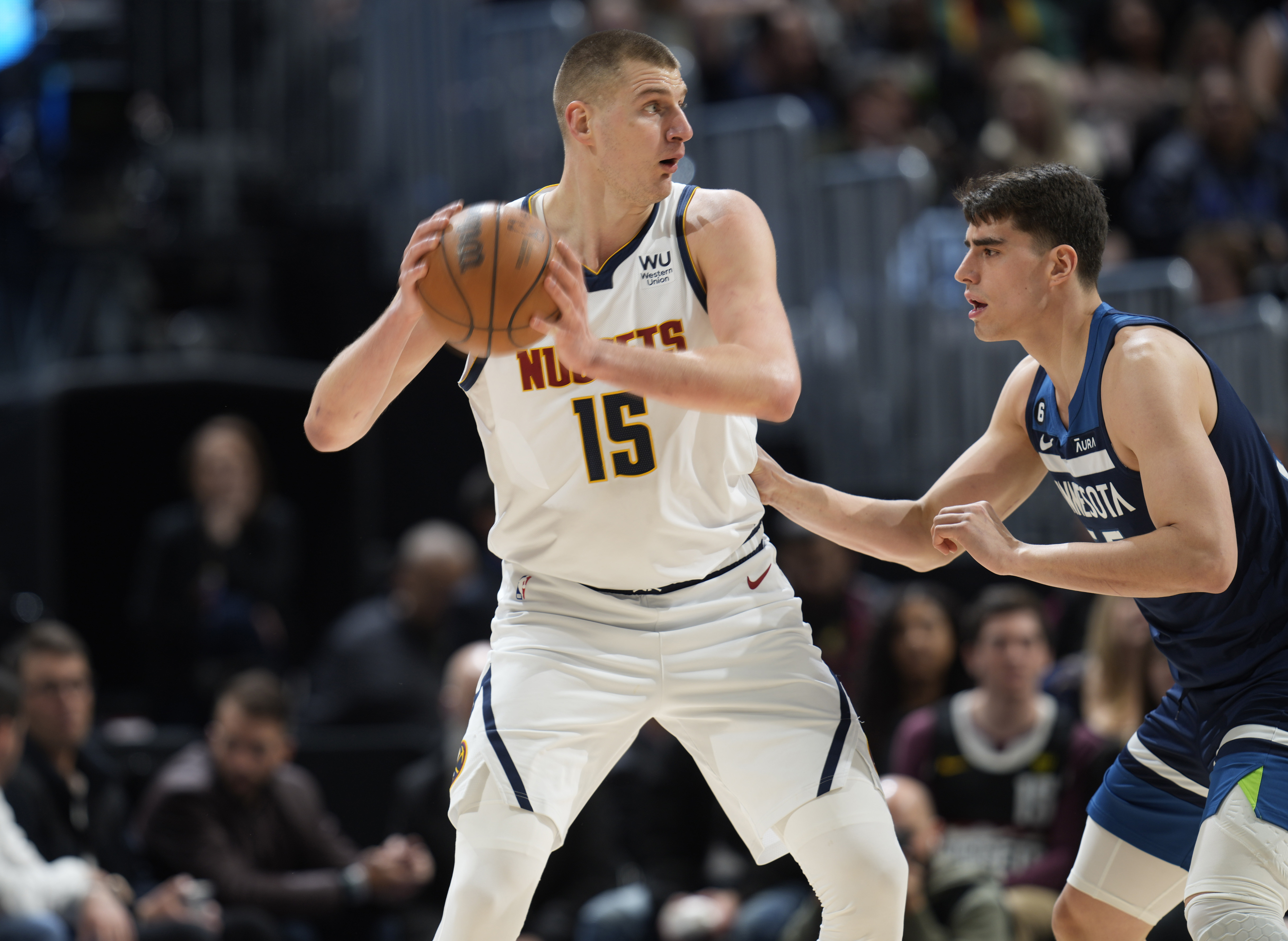 Denver Nuggets center Nikola Jokic, left, looks to pass the ball as Minnesota Timberwolves center Luka Garza defends