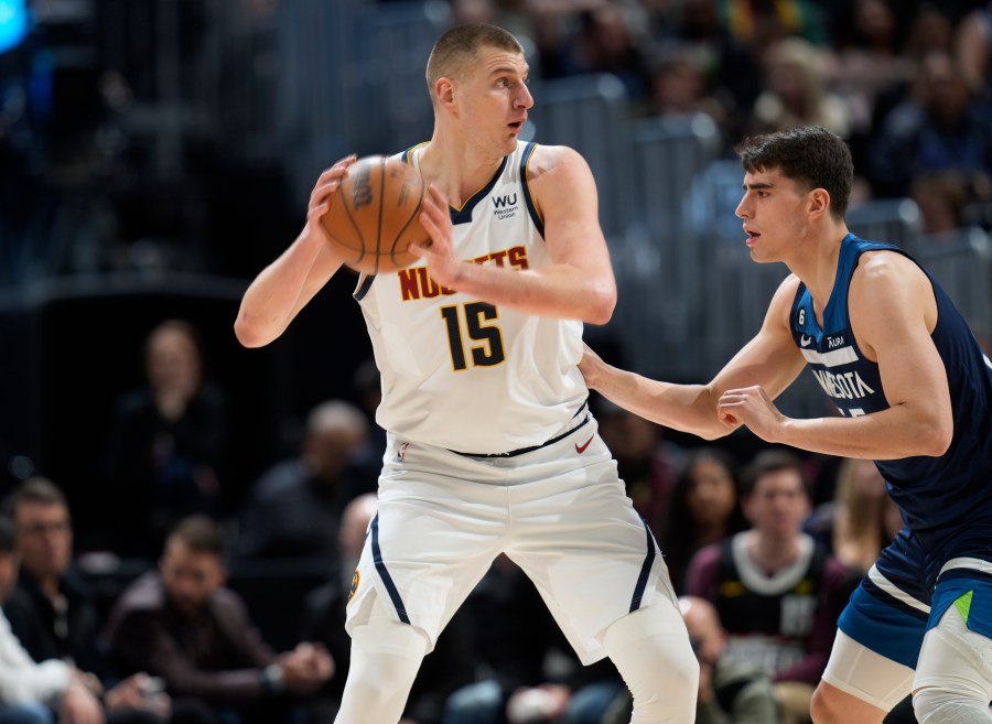 Denver Nuggets center Nikola Jokic, left, looks to pass the ball as Minnesota Timberwolves center Luka Garza defends