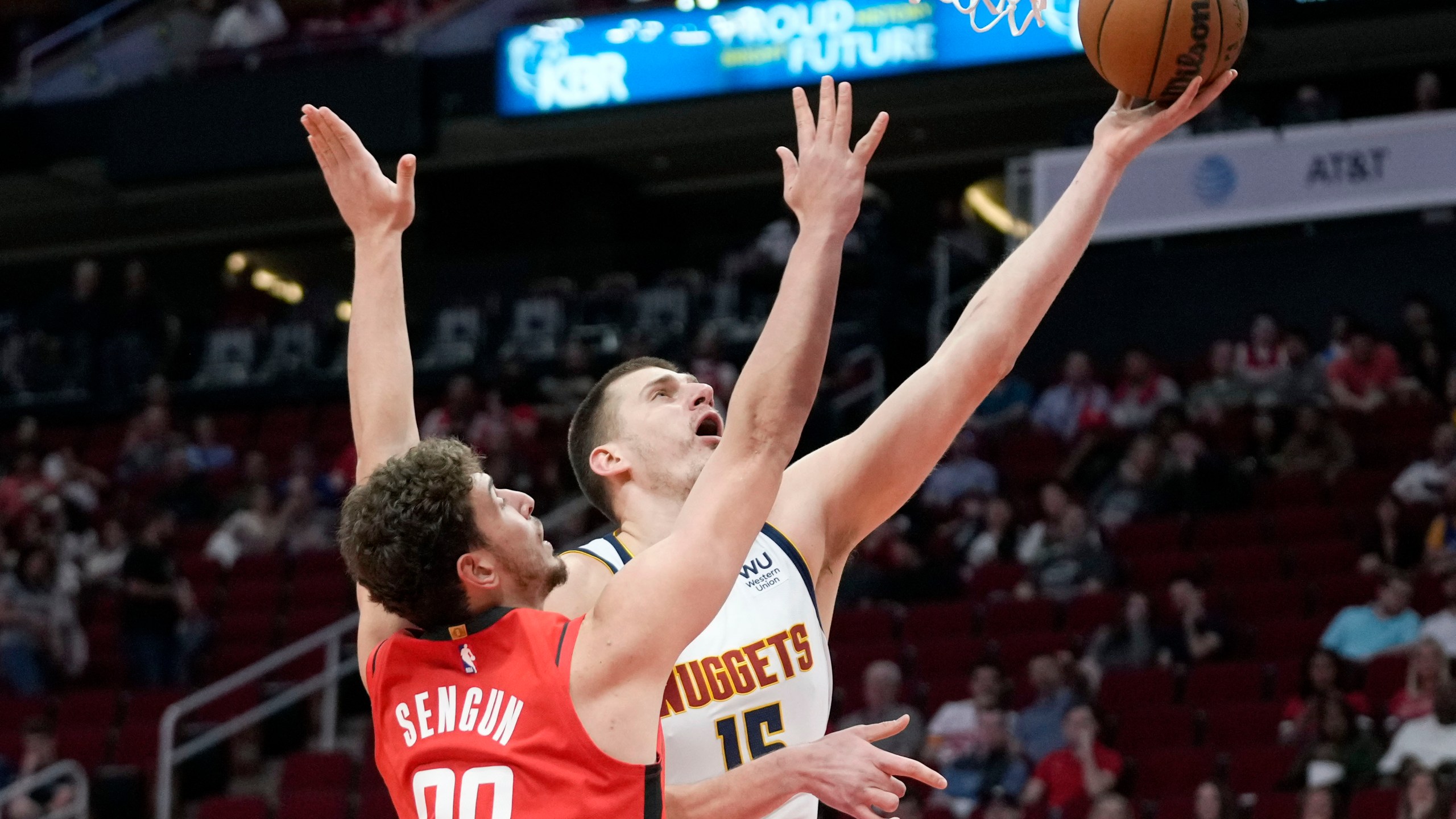 Denver Nuggets center Nikola Jokic, right, shoots as Houston Rockets center Alperen Sengun defends