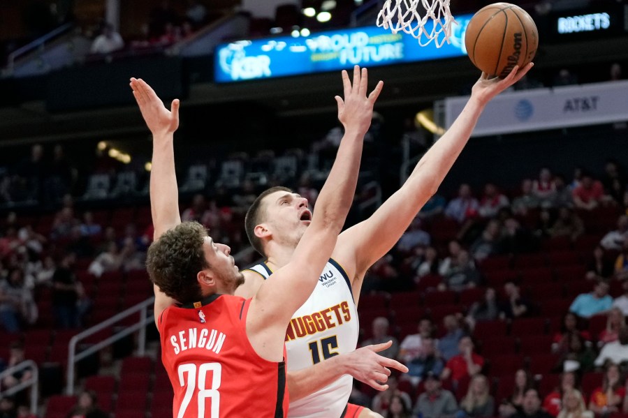 Denver Nuggets center Nikola Jokic, right, shoots as Houston Rockets center Alperen Sengun defends