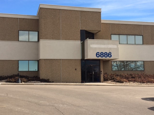 A building in Centennial, Colorado. Above an entrance door is an overhang including a sign with the street number "6886."