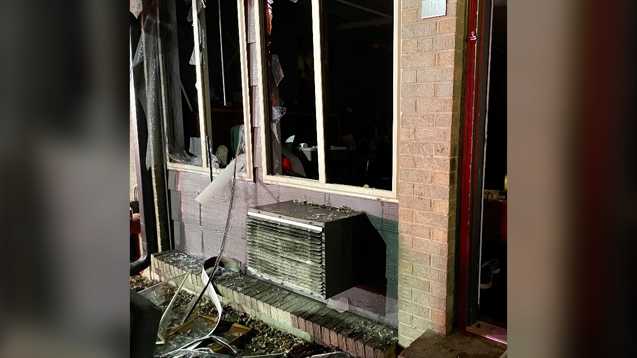 Shattered windows and a fire-damaged window air conditioner on a building