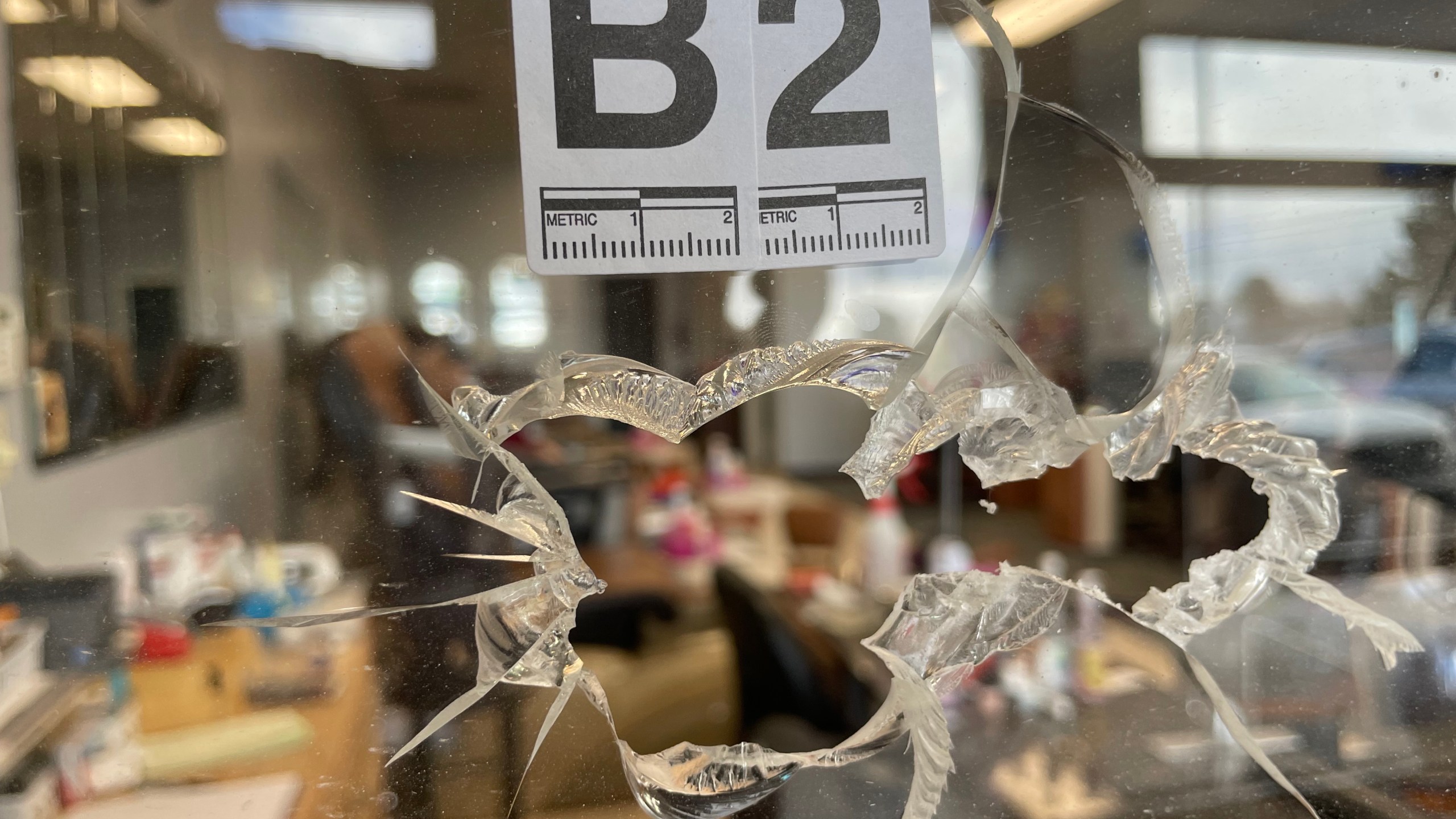 A close-up of a large hole in an acrylic glass sheet at a nail salon counter