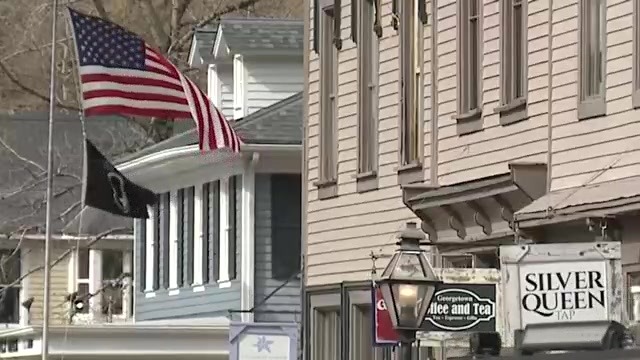 High winds blow U.S. and POW flags on a town street