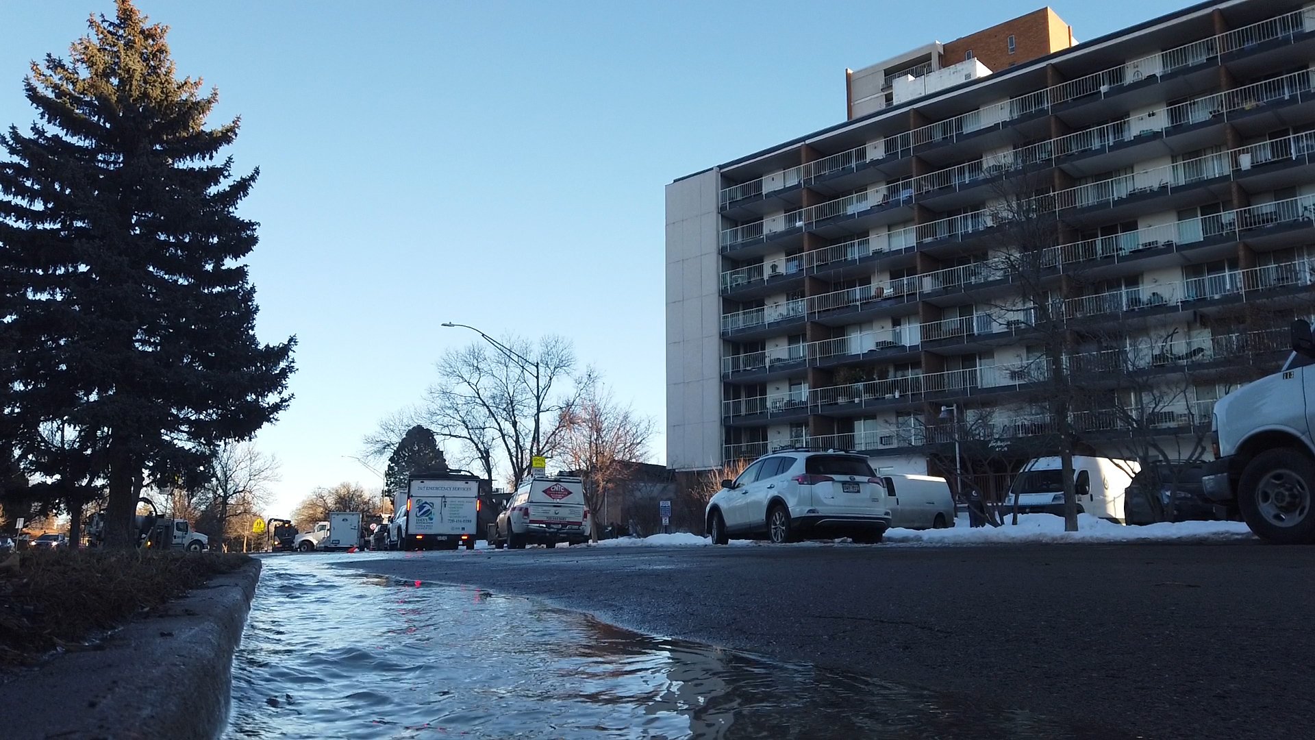 Water in the road next to a high-rise apartment building