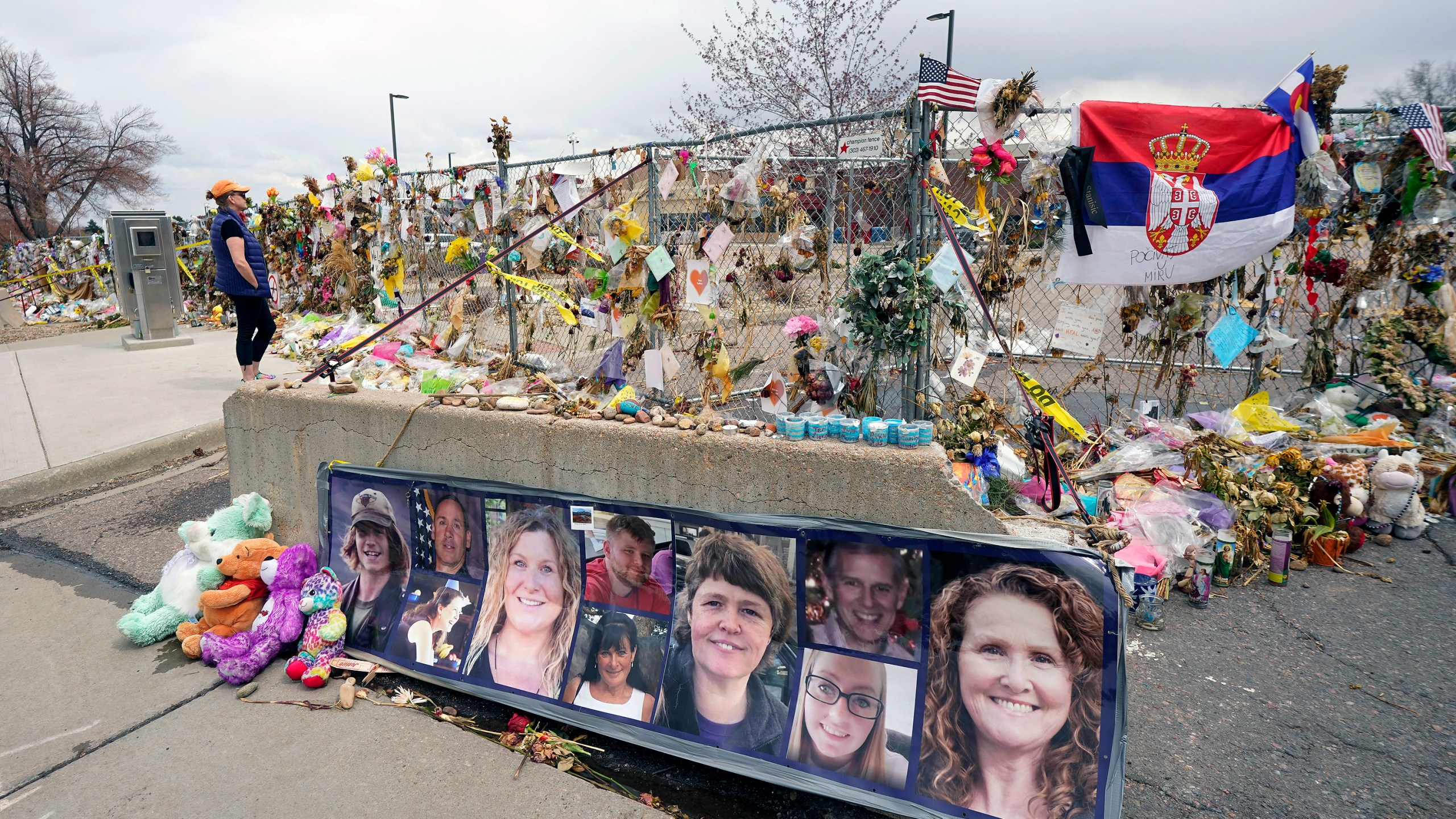 Pictures of the 10 victims of a mass shooting in a King Soopers grocery store are posted on a concrete barrier outside the supermarket