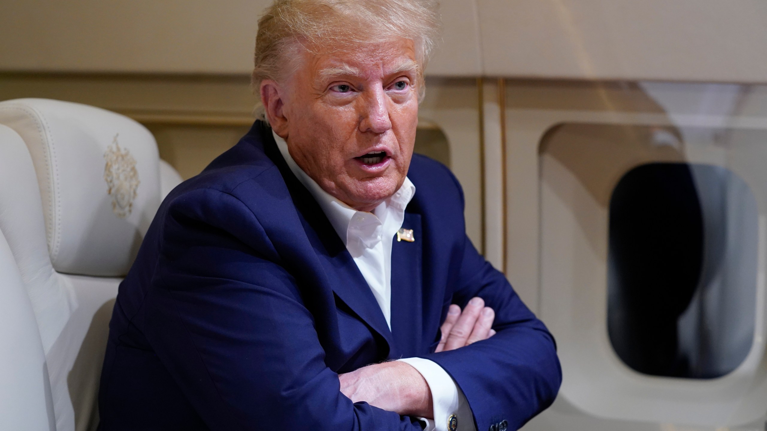 Former President Donald Trump speaks with reporters while in flight on his plane