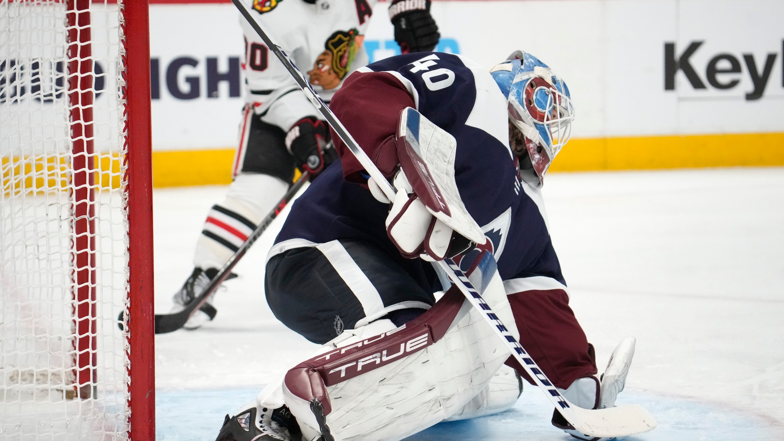 Colorado Avalanche goaltender Alexandar Georgiev, front, makes a glove save of a shot as Chicago Blackhawks center Tyler Johnson covers