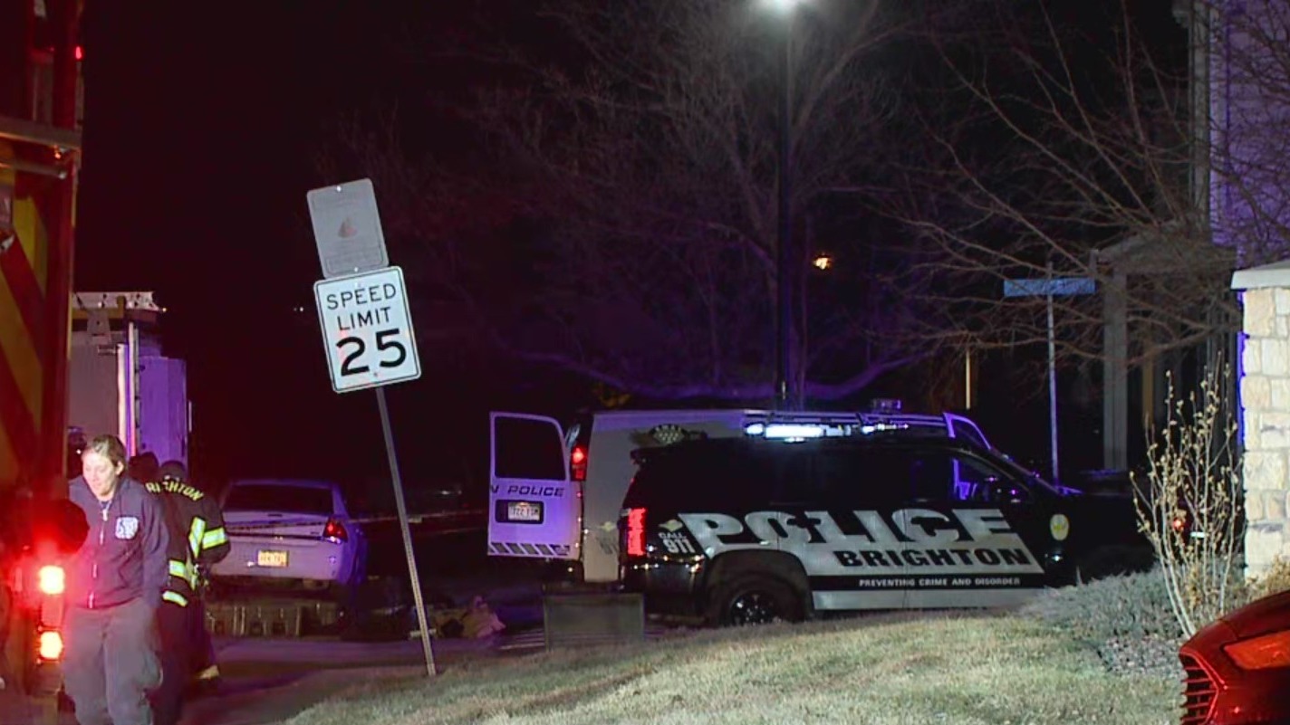 Police SUV and fire truck outside a home at night