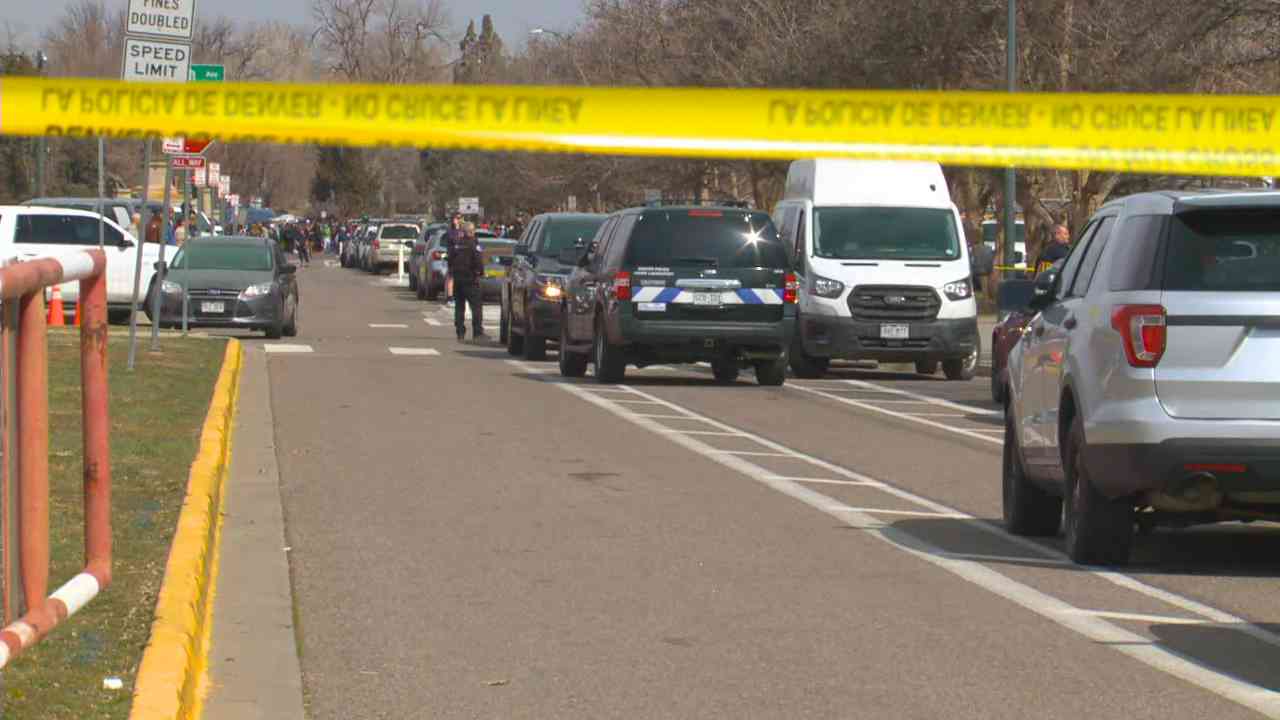 Police tape and emergency vehicles outside East High School in Denver after a shooting on March 22, 2023.