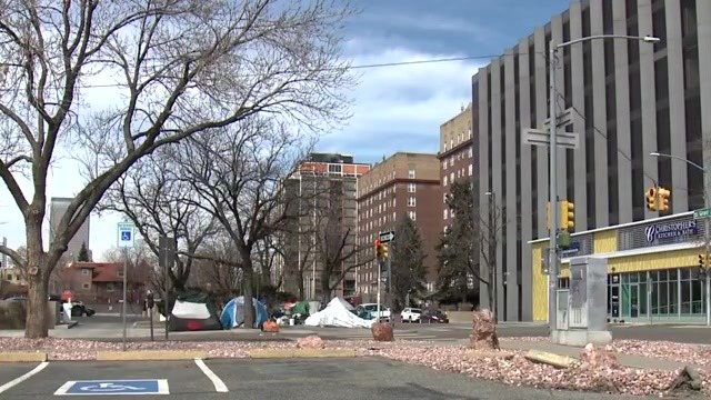 Tents along the street beside high-rise apartment buildings in Denver's Capitol Hill neighborhood