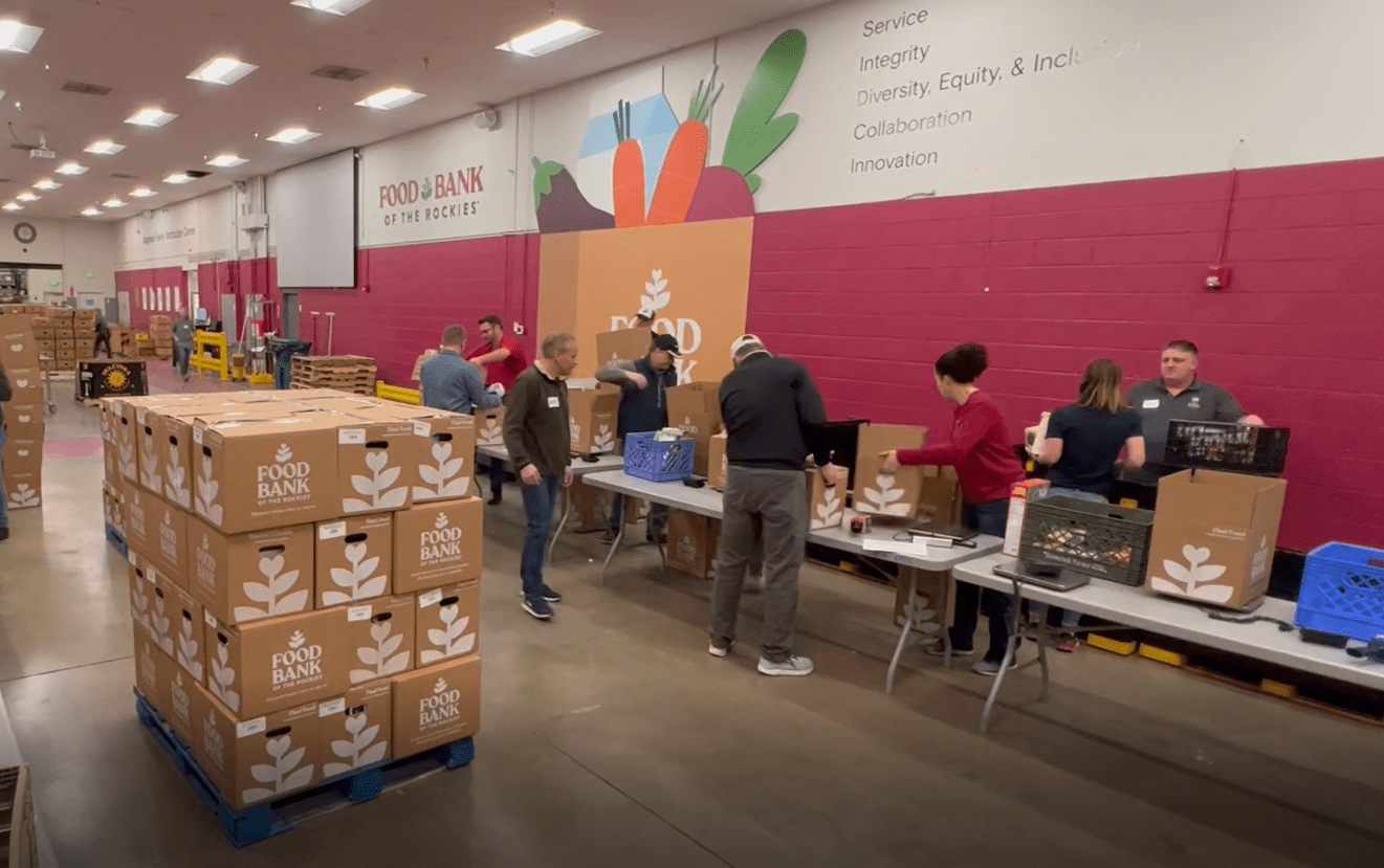 Interior of a warehouse with workers moving stacks of food boxes