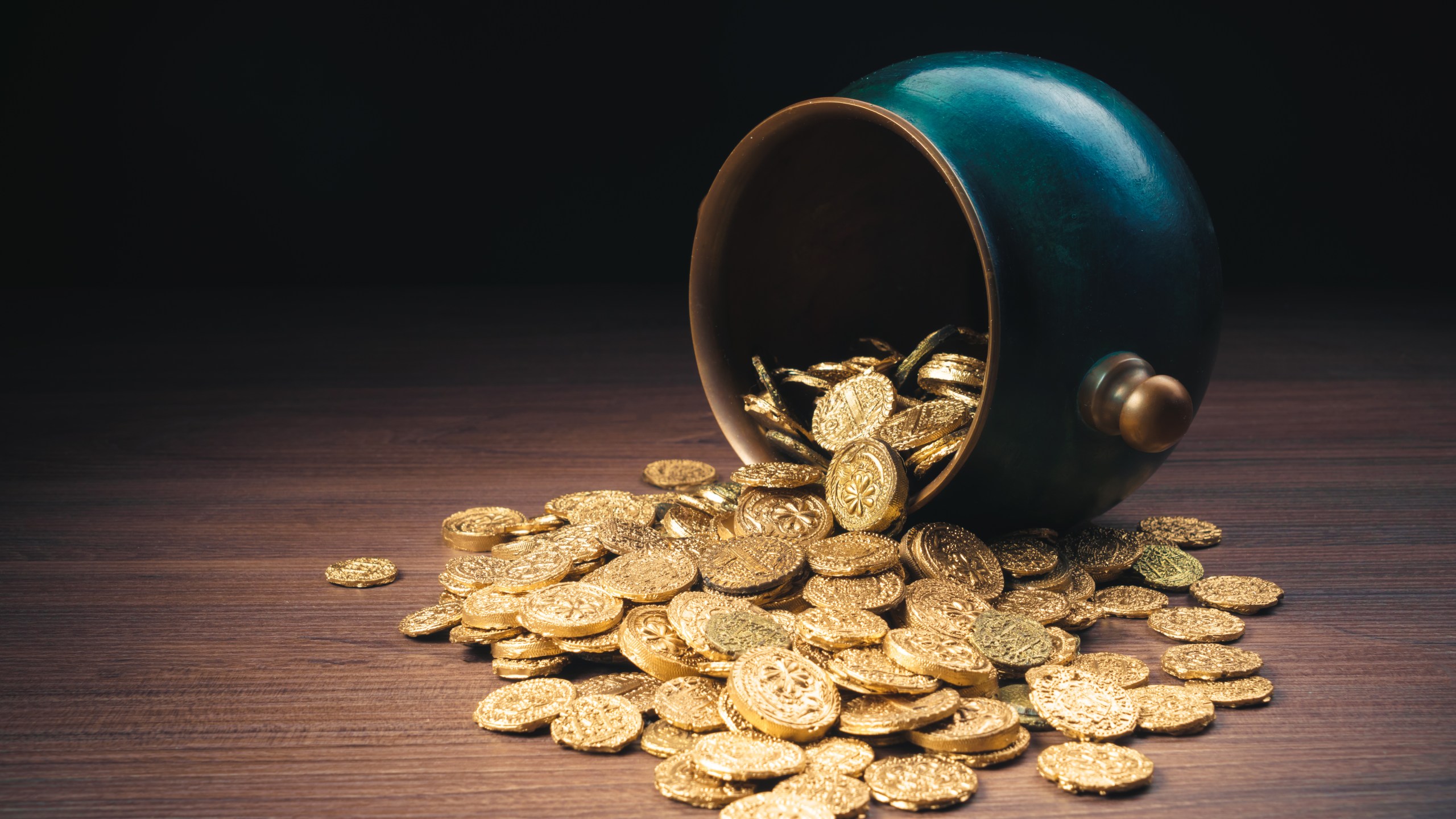 Green pot of gold on top of gold coins