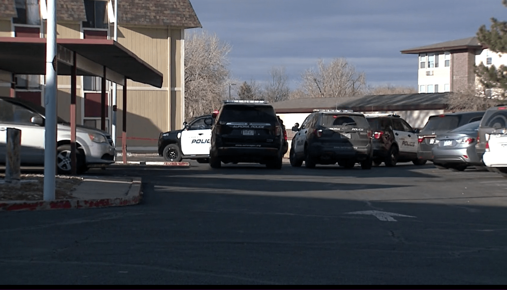 At least 4 Aurora police SUVs in the parking lot of an apartment complex