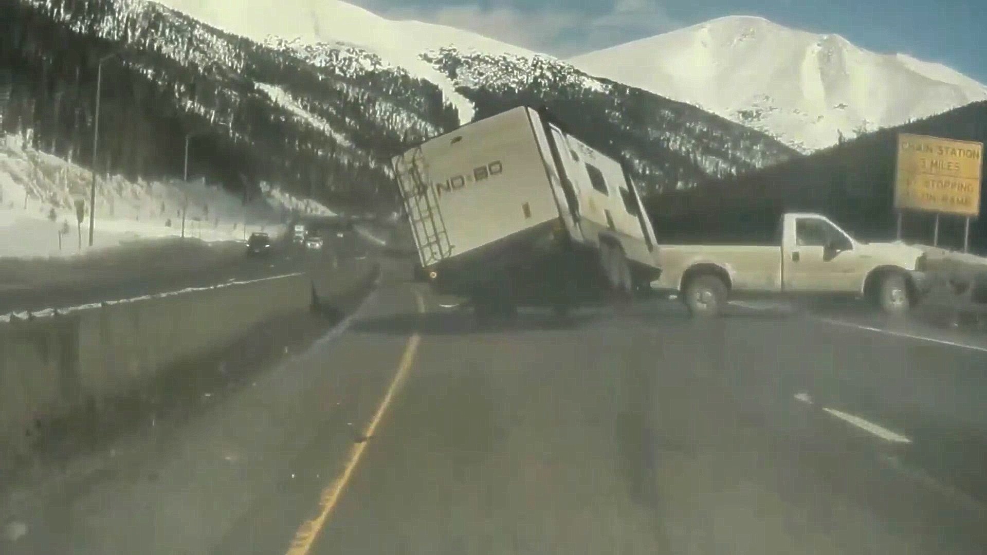 A trailer on a mountain highway midway through turning on its side