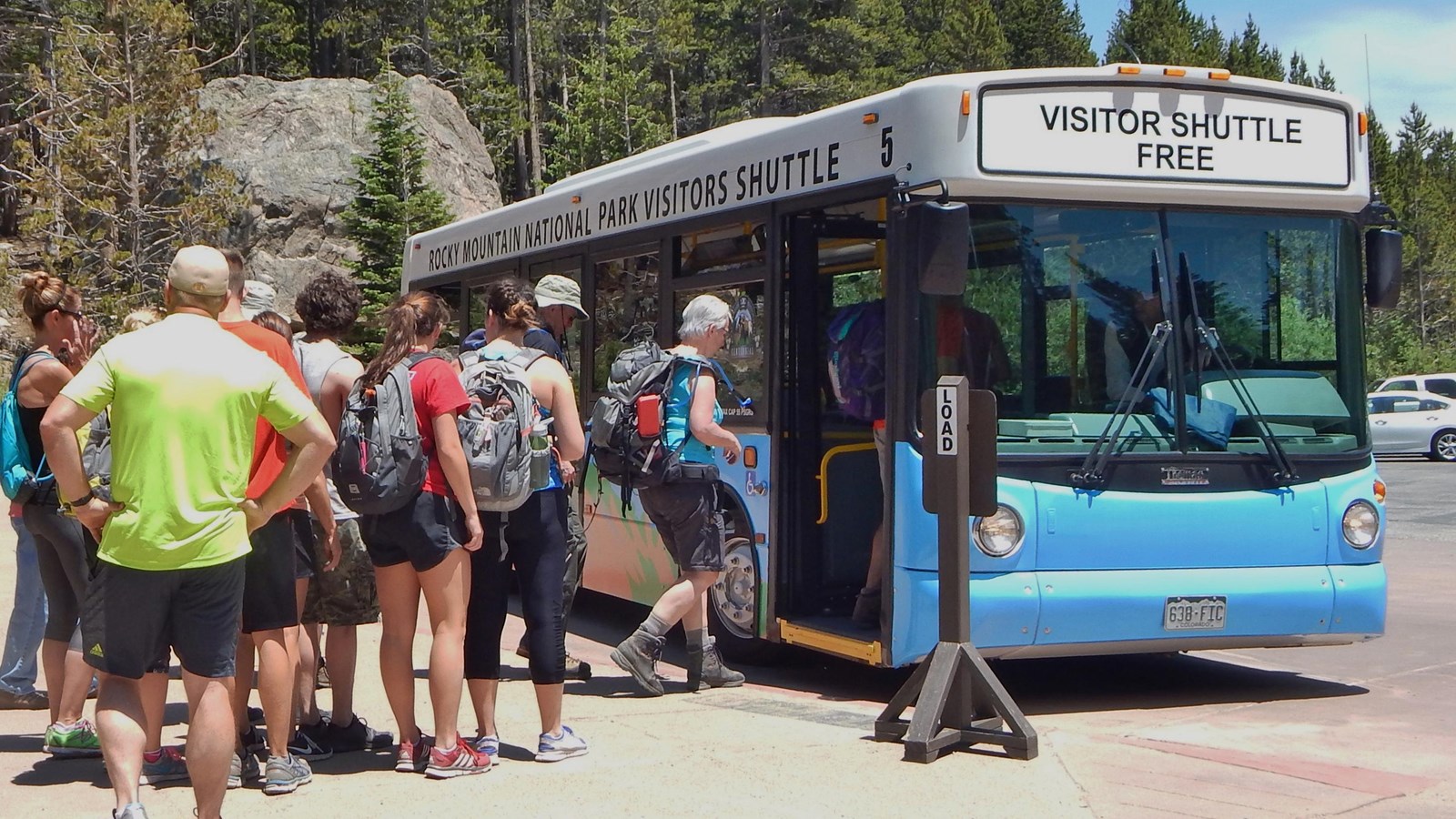 Visitors and hikers board a free visitor shuttle bus at the Rocky Mountain National Park Park & Ride Transit Hub.