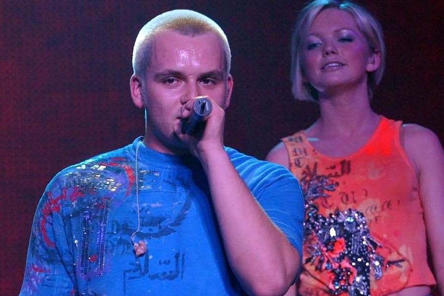 FILE - Paul Cattermole and fellow band mate Hannah looks on as they perform with pop group S Club 7 on stage at Wembley Arena in London, Feb. 14, 2002. Cattermole, a member of early-2000s British pop group S Club 7, has died at the age of 46, it was announced Friday, April 7, 2023. The news comes just weeks after the band announced a reunion tour. (Yui Mok/PA via AP, file)