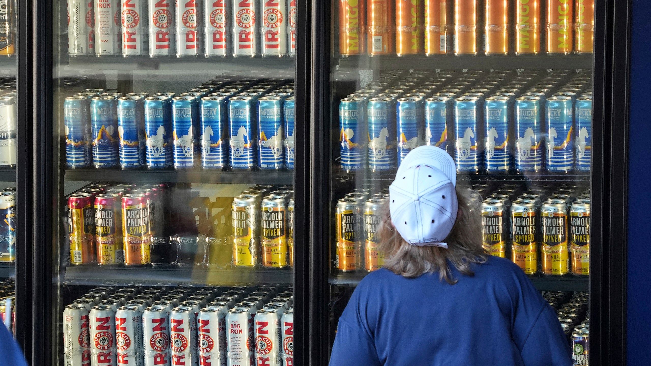 A baseball fan looks at the offerings in a beer cooler at PNC Park before a baseball game between the Pittsburgh Pirates and the Houston Astros in Pittsburgh, Wednesday, April 12, 2023. (AP Photo/Gene J. Puskar)