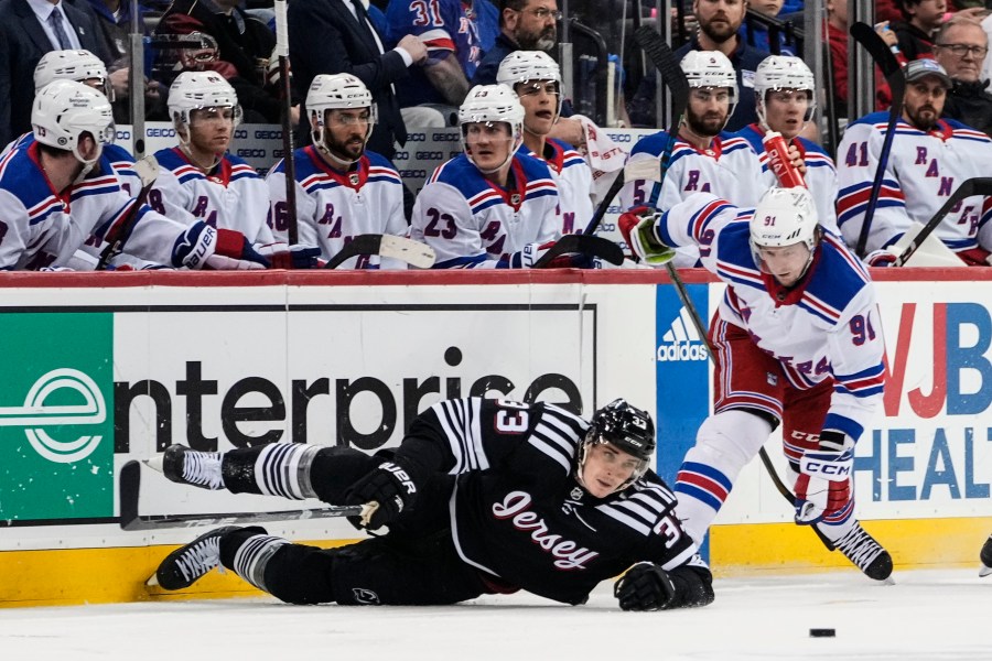 New York Rangers' Vladimir Tarasenko (91) fights for control of the puck with New Jersey Devils' Ryan Graves (33) during the third period of an NHL hockey game Thursday, March 30, 2023, in Newark, N.J. The Devils won 2-1. (AP Photo/Frank Franklin II)