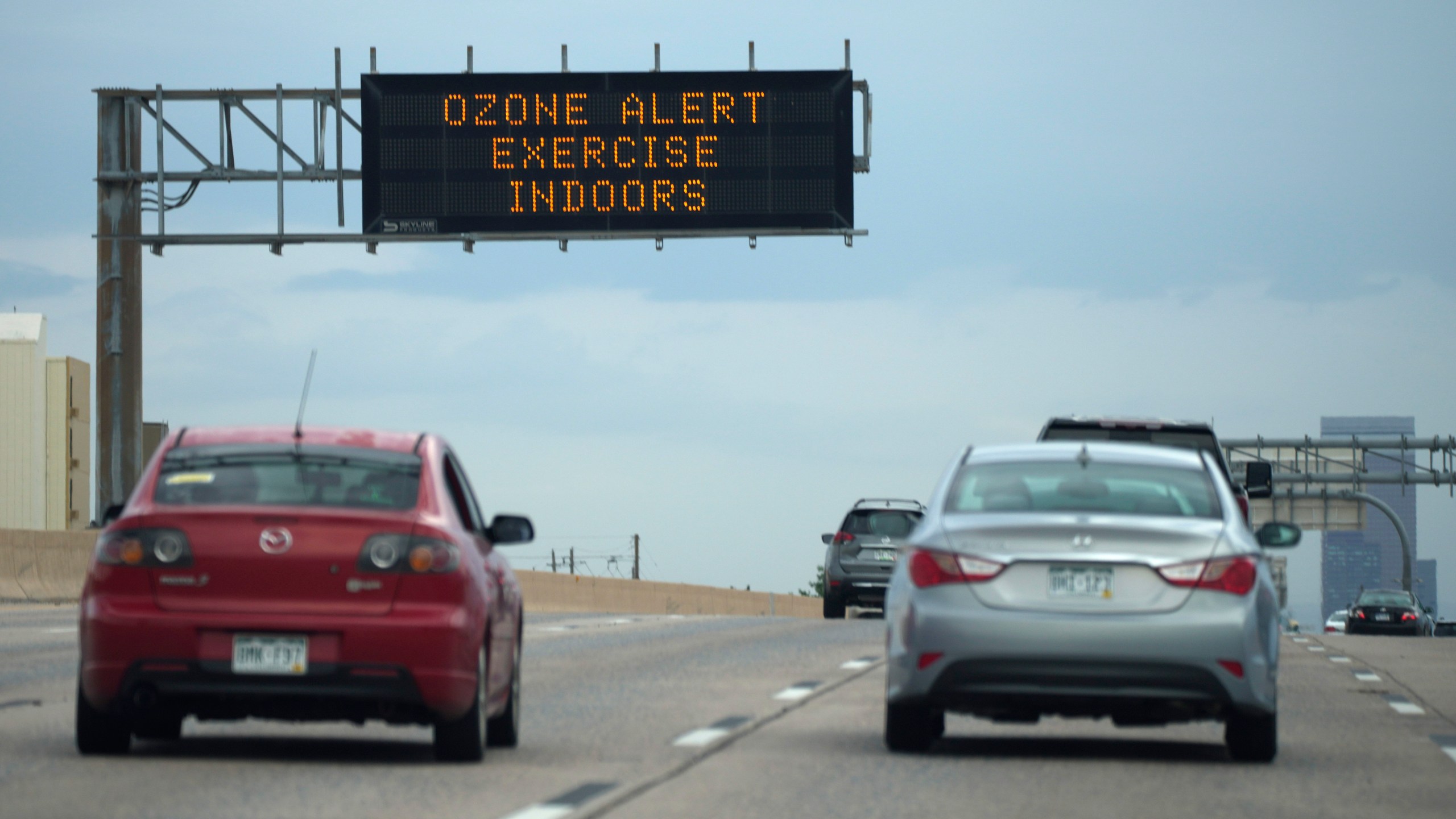 A traffic sign warns of an ozone alert as motorists head southbound on Interstate 25