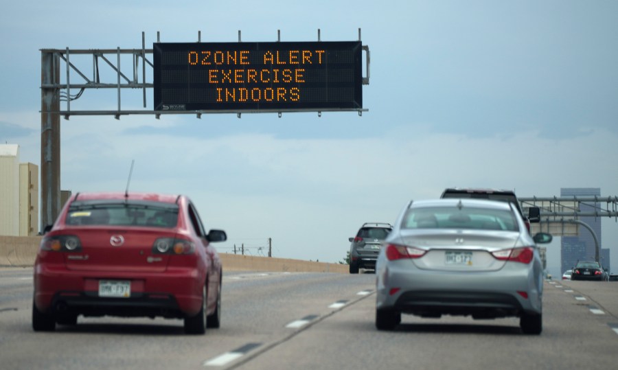 A traffic sign warns of an ozone alert as motorists head southbound on Interstate 25