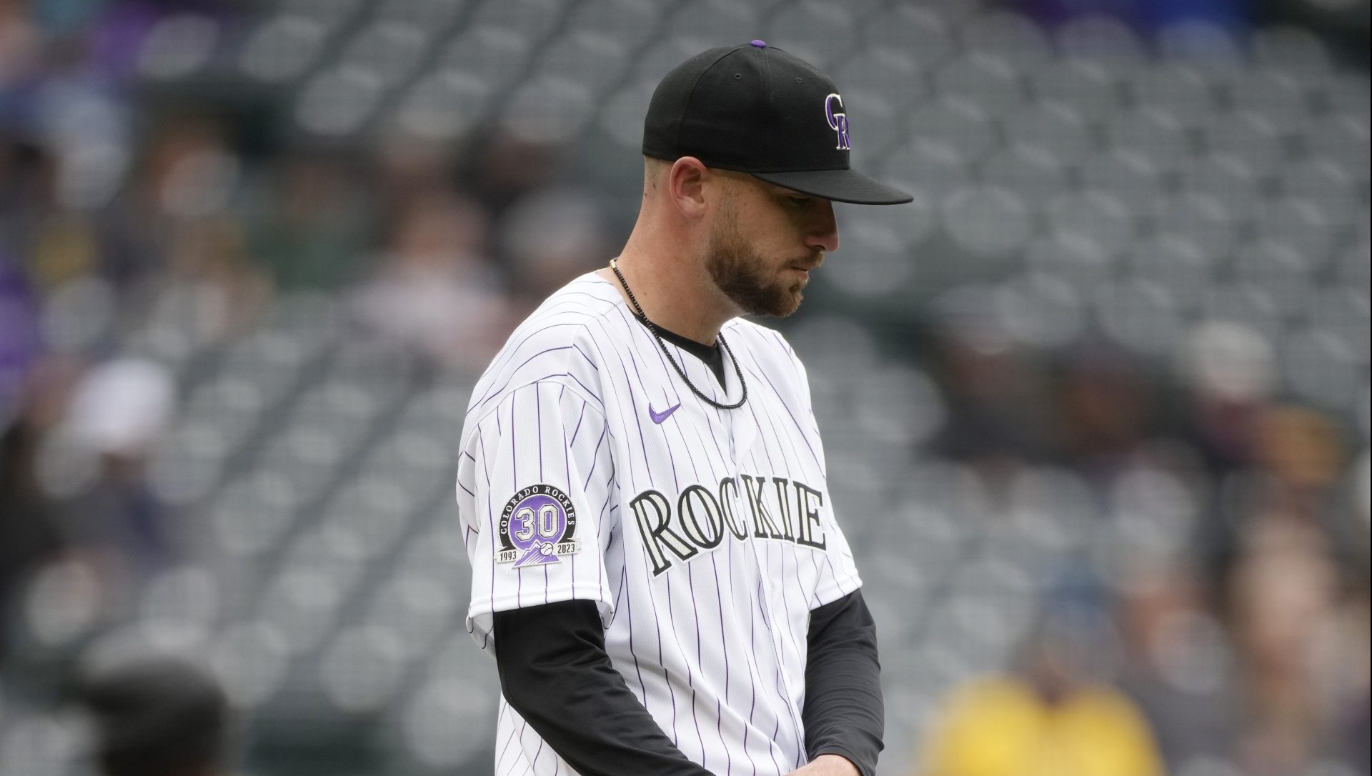 Colorado Rockies starting pitcher Austin Gomber stands with many empty seats behind him at Coors Field, as he reacts after giving up a solo home run to Pittsburgh Pirates' Andrew McCutchen in the second inning on Wednesday, April 19, 2023, in Denver.